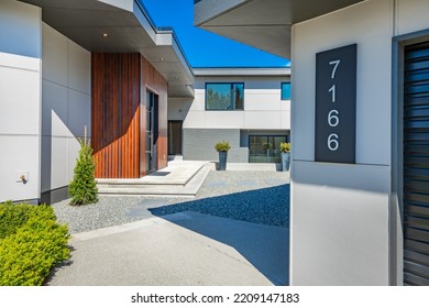 Contemporary Home Exterior On Lakeshore With Flat Roof And Large Feature Windows