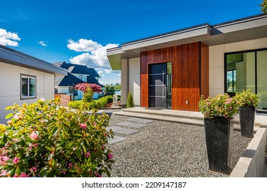 Contemporary Home Exterior On Lakeshore With Flat Roof And Large Feature Windows