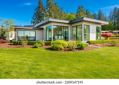 Contemporary Home Exterior On Lakeshore With Flat Roof And Large Feature Windows