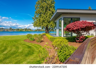 Contemporary Home Exterior On Lakeshore With Flat Roof And Large Feature Windows