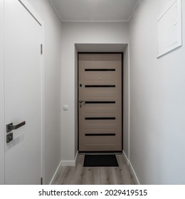 Contemporary Interior Of Modern Apartment. Front View Of Entrance Door. White Walls. Parquet Floor.