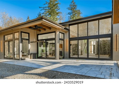 Contemporary modern home exterior with black framed floor to ceiling windows cedar siding painted white brick walls glass and black garage doors elegant slim line exterior light fixtures and flat roof