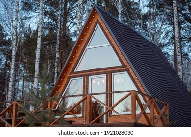 Contemporary new large country house standing in mixed forest in front of camera on background of pine trees and birches growing together - Powered by Shutterstock