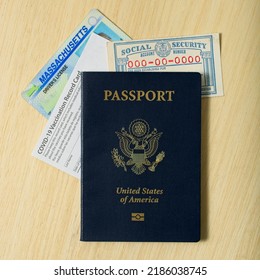 Contemporary Personal Identification Information Set Of Passport Social Security Real ID And COVID-19 Vaccination Card All Lying On Wooden Tabletop.