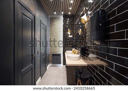 Contemporary restroom in dark colors and black tiles