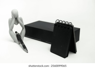 Contemporary smartphone and complementary items, including a charging adapter, USB cable, pen, and notebook, arranged on a minimalistic white surface.