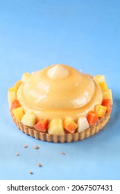 Contemporary Tropical Fruit Multi-Layered Mousse Tart On Blue Background.