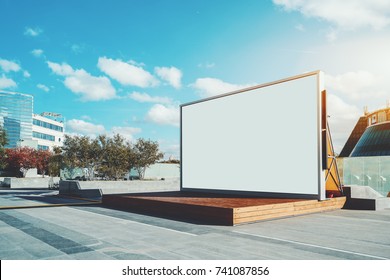 Contemporary wooden stage in urban settings with blank information LCD screen or banner; empty mock-up of poster; white clean billboard with copy space zone for logo, text or advertising caption