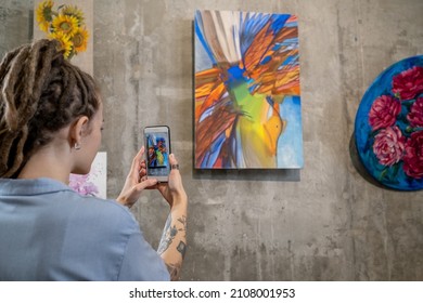 Contemporary Young Woman Taking Photo Of Abstract Painting On Wall While Visiting Exhibition In Art Gallery At Leisure