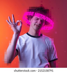 Contemporay artwork. Emotive youg man with neon lettering around pixel head showing OK gesture isolated over pink background. Concept of digitalization, artificial intelligence, technology era
