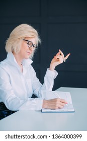 Content Aged Lady At Work. Busy With Agenda Items. Smiling Senior Woman Making Notes In Diary. Career Development.