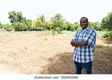 Content black African farmer is standing in front of a newly acquired, unplanted piece of land, intended for growing vegetables - Shutterstock ID 2024492486