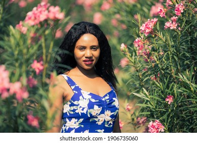 Content Black Woman Smelling Flowers In Park