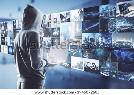 Content creation concept with guy in hoody with laptop and virtual all with video shots on background