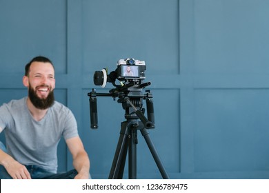 content creation for social media. bearded man shooting video of himself using camera on tripod. modern technology and blogging freelance work concept.