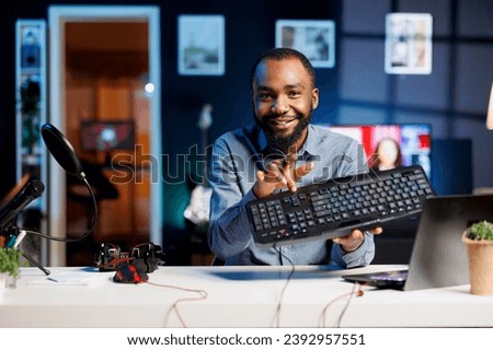 Content creator using high quality recording devices to shoot keyboard review for vlog channel on online platforms. Internet star warmly welcoming dedicated viewers, filming computer peripheral