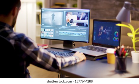Content creator using modern software for video post production in home office during night hours.