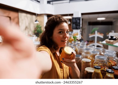 Content creator using selfie camera to make video for social media channels, presenting newly opened zero waste store. Vlogger filming herself inside bulk products local neighborhood supermarket