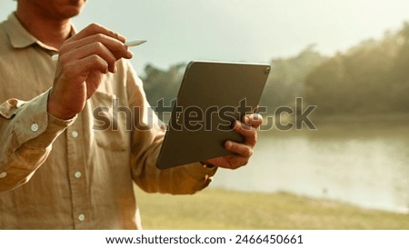 Content creator writing script or production design with digital tablet to create new project in beautiful location.