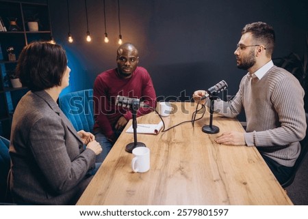 Content creators interviewing in professional studio, capturing conversation with high end microphones