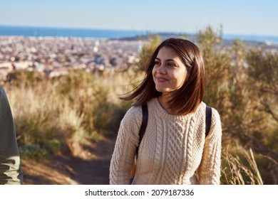 Content Lady Walking Uphill With A Friend With The City In The Background