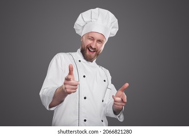 Cocina masculina de contenido con uniforme de chef blanco apuntando a la cámara mostrando que queremos que se haga un gesto por el concepto de reclutamiento