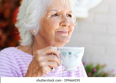 A Content Old Woman Holding A Cup Of Tea