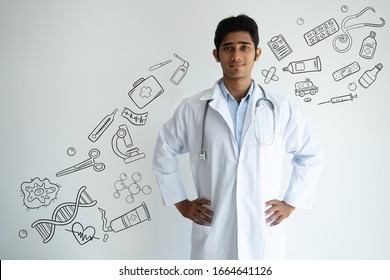 Content Physician In Lab Coat With Hand Drawn Medical Sketches. Man Holding Hands On Hips. Serious Confident Handsome Indian Male Doctor Working In Hospital. Healthcare And Medicine Concept