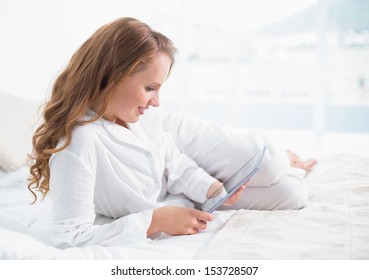 Content Pretty Woman Using A Tablet Pc Lying On Her Bed In A Bedroom