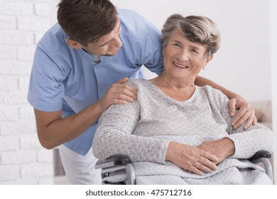 Content Senior Woman And Her Professional Male Carer, Light Interior