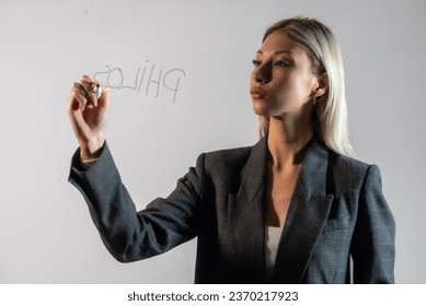 A content that can be used as a teacher, academician or businesswoman. Female model writes on a transparent board. - Powered by Shutterstock