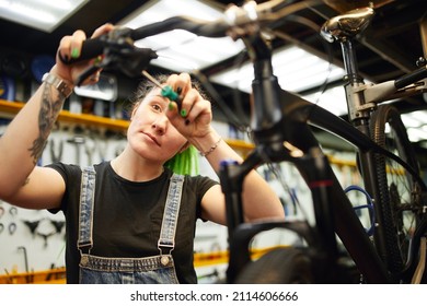 Content Woman Repairing Bike In Workshop