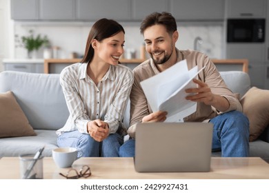 Content young spouses with papers and laptop computer, engaged in discussion and financial planning in cozy living room setting at home, sitting on couch - Powered by Shutterstock