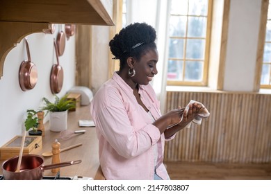 Contented African Woman In Pink Clothes Drying Hands