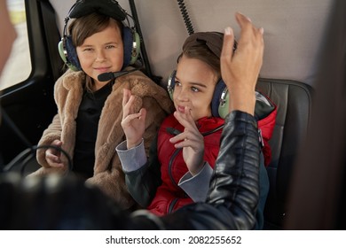 Contented Kids In Safety Gear Having A Helicopter Ride