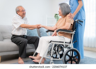 A contented senior couple and their in-home nurse. Elderly female in wheelchair with her young caregiver. - Shutterstock ID 2206074137