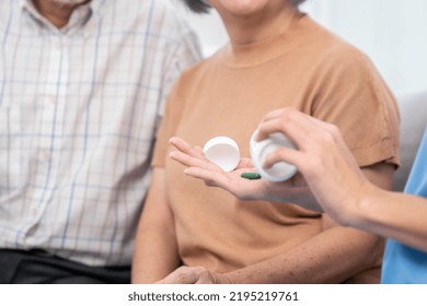 Contented Senior Woman Sit Along Side With Her Husband, Taking Medicines While Her Caregiver Advising Her Medication. Medication For Seniors, Nursing House, Healthcare At Home.