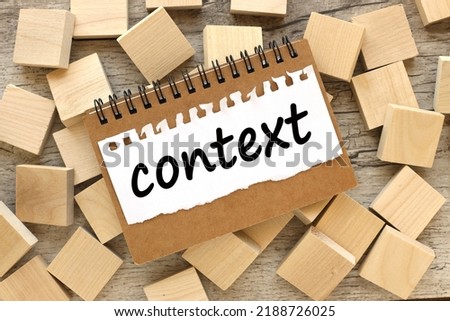 CONTEXT. text on paper. on wooden blocks. wooden background