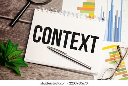 context words on notepad with magnifying glass and charts - Shutterstock ID 2203930673