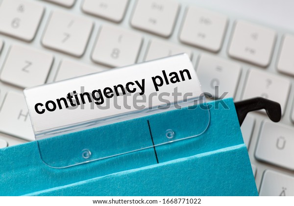 contingency plan is on a label of a\
blue hanging file. In the background a computer\
keyboard