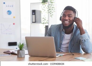 Continuing Education Program. Smiling African American Employee In Headphones Watching Webinar On Laptop In Modern Office.