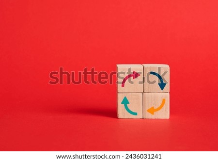 Continuous improvement and business cycle or processes. Process management and continuity. Round arrows in various colors on wooden cubes building a cycle on red background.
