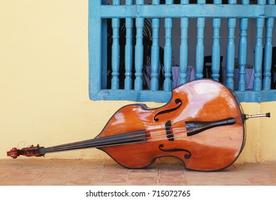 Contrabass Lying On Tiled Floor Outside Hacienda In Manacas Iznaga, Trinidad, Cuba