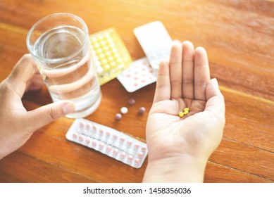 Contraceptive pill prevent pregnancy contraception concept / Woman holding pill and glass of water in hands taking emergency medicine birth control  - health care and medicine