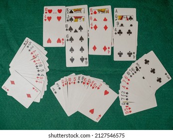 Contract Bridge demonstration all four hands as dealt out face up on a green baize card table before bidding commences