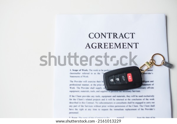contract document with\
car and remote key. buy and sale, insurance, rental and contract\
agreement concepts