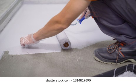 Contract Painter Painting Garage Floor To Speed Up Selling Of Home. Paint The Floor With A Roller.