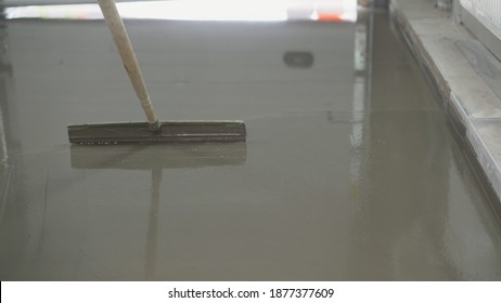 Contract Painter Painting Garage Floor To Speed Up Selling Of Home. Fill Screed Floor Repair And Furnish, Shallow Dof. Old Grunge Background Texture Or Rough Surface Background. Pour The Floor In A