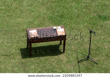 Contract papers and pens on wooden desk. Announcement work agreement with microphone, making a deal, agreement signing, free space, copy space, place for text. Office yard outdoor concept