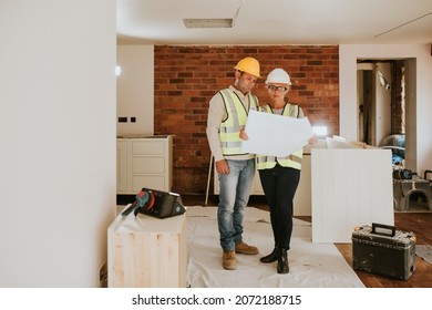 Contractor Coworkers Working Together On Remodeling Home